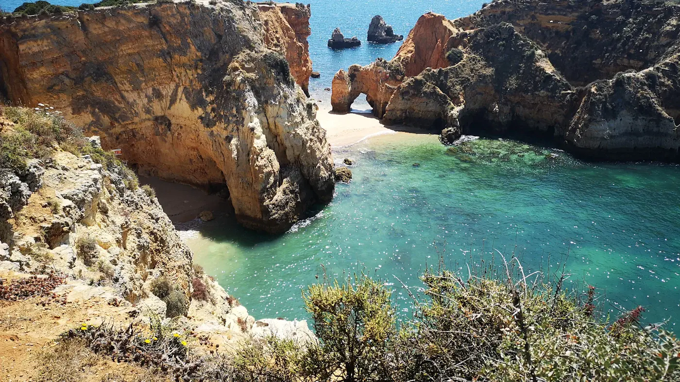 Turquoise water in a rocky cove on the Algarve coast, seen from the cliff top