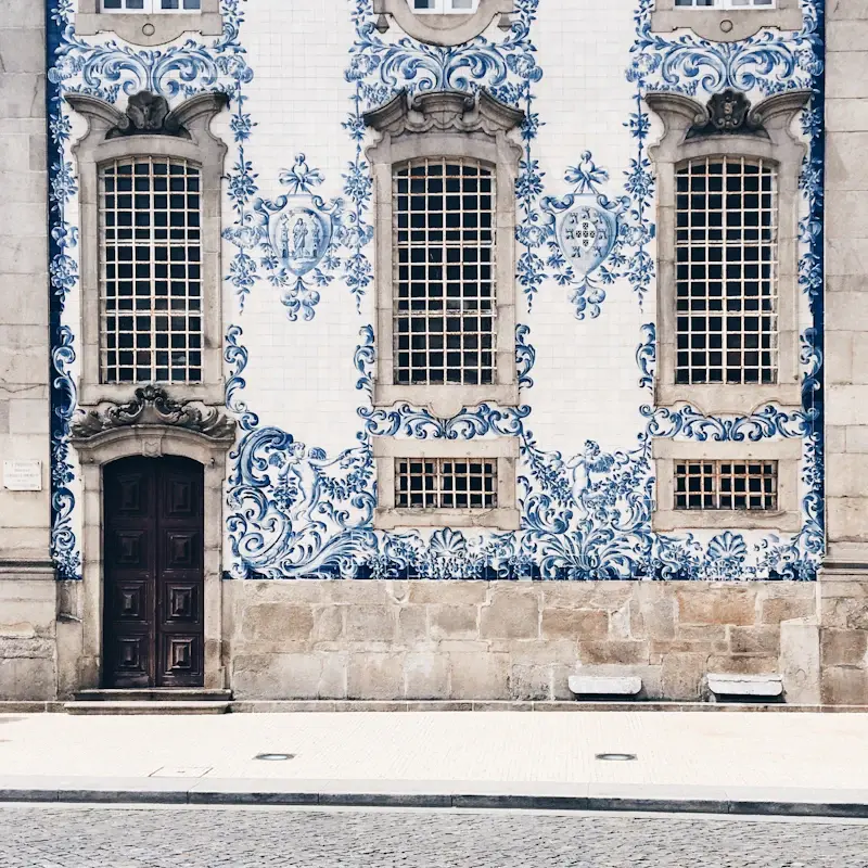 A building front covered in blue and white azulejo tiles, with a dark wooden door