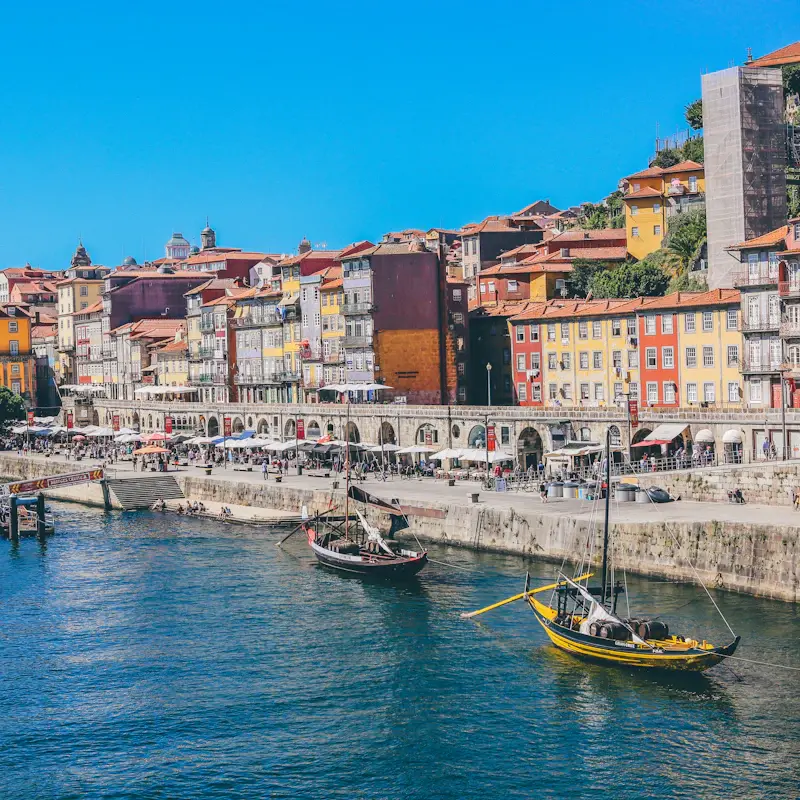 Wooden rabelo boats moored on the Douro below the colourful houses of the Ribeira in Porto