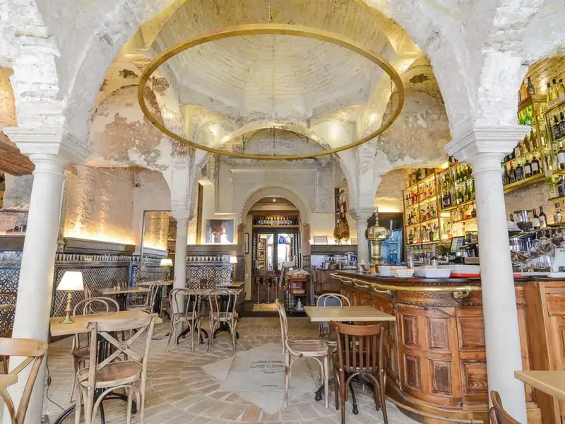 Inside Cervecería Giralda: a whitewashed vaulted room with a dome, tiled walls and the bar