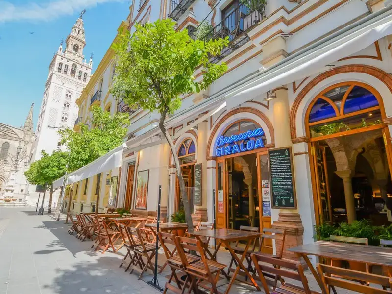 Tables outside Cervecería Giralda, with the Giralda tower at the end of the street