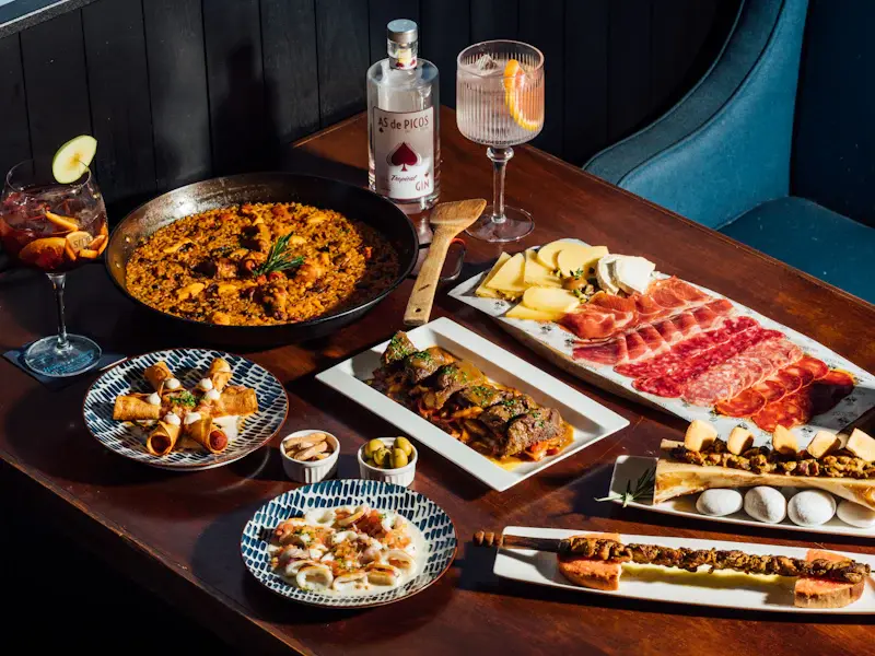 Several tapas dishes and drinks laid out on a table