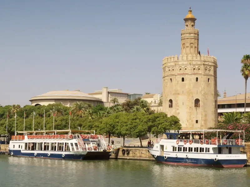 Tour boats moored on the Guadalquivir in front of the Torre del Oro