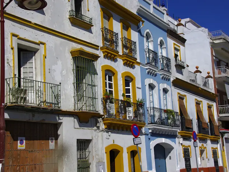 A row of colourful houses with wrought-iron balconies in Triana